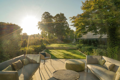 Large contemporary backyard full sun formal garden in London with a garden path and natural stone pavers.