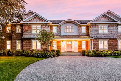 Inspiration for a large coastal brown two-story wood exterior home remodel in New York with a shingle roof