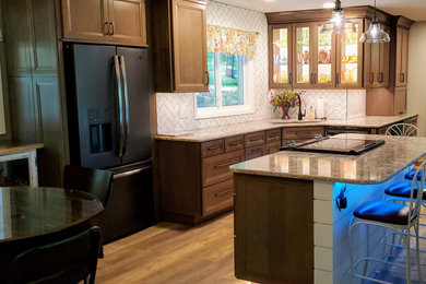 Mid-sized transitional vinyl floor and beige floor open concept kitchen photo in Other with an undermount sink, recessed-panel cabinets, gray cabinets, quartz countertops, white backsplash, subway tile backsplash, black appliances, an island and beige countertops