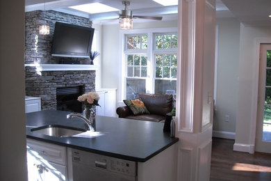 Inspiration for a mid-sized transitional l-shaped medium tone wood floor and brown floor kitchen remodel in Dallas with an undermount sink, raised-panel cabinets, white cabinets, stainless steel appliances, an island and soapstone countertops