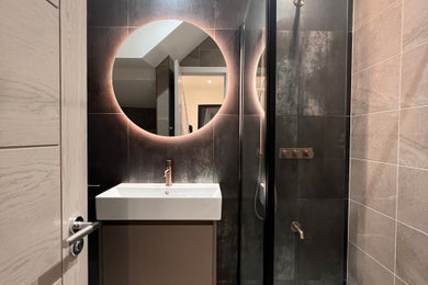 Inspiration for a medium sized contemporary bathroom with flat-panel cabinets, beige cabinets, a wall mounted toilet, porcelain tiles, brown walls, porcelain flooring, a built-in sink, beige floors, an open shower, a feature wall, a single sink and a floating vanity unit.