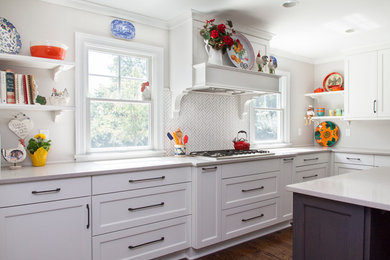 Enclosed kitchen - large farmhouse l-shaped dark wood floor enclosed kitchen idea in New York with a farmhouse sink, shaker cabinets, white cabinets, quartz countertops, white backsplash, mosaic tile backsplash, paneled appliances and an island