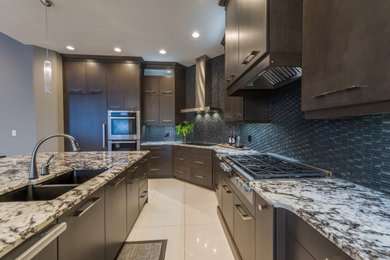 This is an example of an expansive traditional single-wall eat-in kitchen in Edmonton with an undermount sink, flat-panel cabinets, dark wood cabinets, granite benchtops, black splashback, glass tile splashback, stainless steel appliances, ceramic floors, with island, white floor and multi-coloured benchtop.