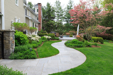 This is an example of a large traditional backyard rectangular natural pool in New York with concrete pavers.
