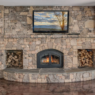 Photo of a large traditional walk-out basement in Other with beige walls, concrete flooring, a wood burning stove and a stone fireplace surround.