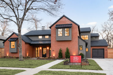 Idées déco pour une grande façade de maison rouge moderne en stuc à un étage avec un toit à deux pans, un toit mixte et un toit noir.
