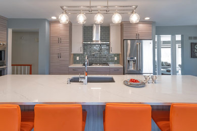 This is an example of a large modern eat-in kitchen in Milwaukee with an undermount sink, grey cabinets, quartz benchtops, green splashback, glass tile splashback, stainless steel appliances, dark hardwood floors, with island, brown floor and white benchtop.