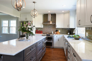 Example of a transitional l-shaped medium tone wood floor eat-in kitchen design in Orange County with a double-bowl sink, shaker cabinets, white cabinets, marble countertops, gray backsplash, glass tile backsplash, stainless steel appliances and an island