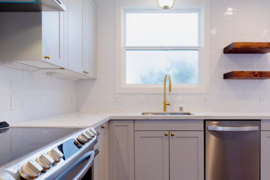 Enclosed kitchen - small contemporary l-shaped brown floor enclosed kitchen idea in San Francisco with an undermount sink, shaker cabinets, white cabinets, marble countertops, white backsplash, ceramic backsplash, stainless steel appliances and white countertops
