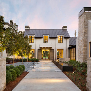 Idéer för stora funkis beige hus, med två våningar, stuckatur och tak i metall