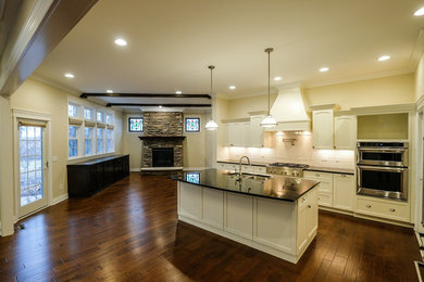 Eat-in kitchen - large transitional l-shaped dark wood floor and brown floor eat-in kitchen idea in Other with an undermount sink, recessed-panel cabinets, white cabinets, granite countertops, white backsplash, stainless steel appliances, an island and blue countertops