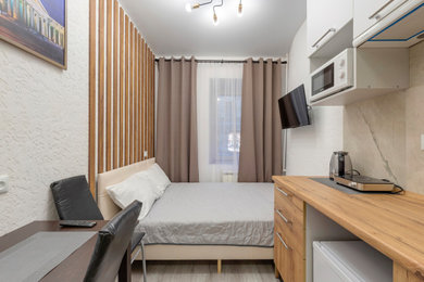 Пример оригинального дизайна: маленькая гостевая спальня (комната для гостей) в скандинавском стиле с белыми стенами, полом из керамогранита и коричневым полом без камина для на участке и в саду