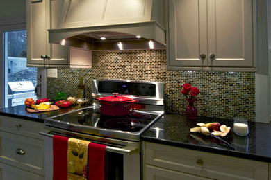 Mid-sized elegant eat-in kitchen photo in Philadelphia with a farmhouse sink, light wood cabinets, multicolored backsplash, stainless steel appliances and an island