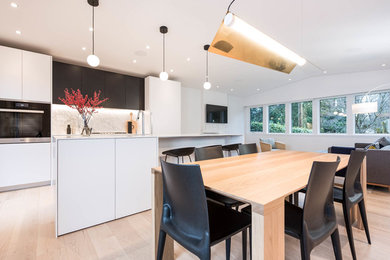 This is an example of a mid-sized contemporary eat-in kitchen in Vancouver with a double-bowl sink, white cabinets, solid surface benchtops, white splashback, marble splashback, panelled appliances, light hardwood floors, with island and beige floor.