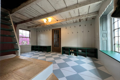 Bild på en stor vintage entré, med grå väggar, målat trägolv och flerfärgat golv