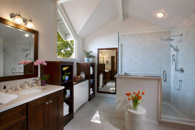 Corner shower - large coastal master white tile and ceramic tile ceramic tile and white floor corner shower idea in Los Angeles with recessed-panel cabinets, brown cabinets, a one-piece toilet, white walls, an undermount sink, granite countertops and a hinged shower door