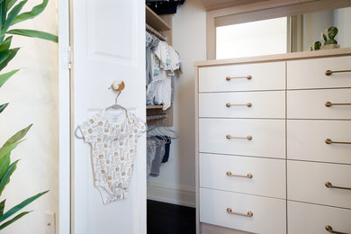 Inspiration for a small country gender-neutral walk-in wardrobe in Minneapolis with flat-panel cabinets, medium wood cabinets, painted wood floors and black floor.