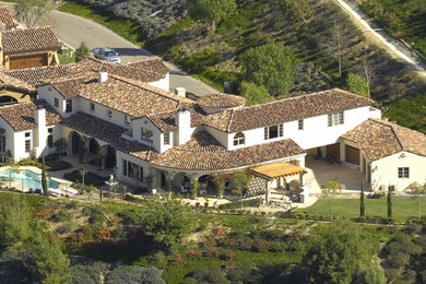 Huge mediterranean white two-story stucco gable roof idea in San Diego