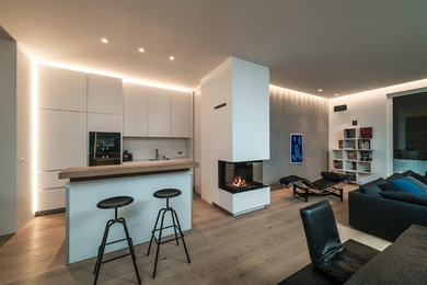 Zweizeilige, Mittelgroße Moderne Wohnküche mit Einbauwaschbecken, flächenbündigen Schrankfronten, weißen Schränken, Arbeitsplatte aus Holz, Küchenrückwand in Weiß, schwarzen Elektrogeräten, braunem Holzboden, Halbinsel, braunem Boden und Glasrückwand in Stuttgart