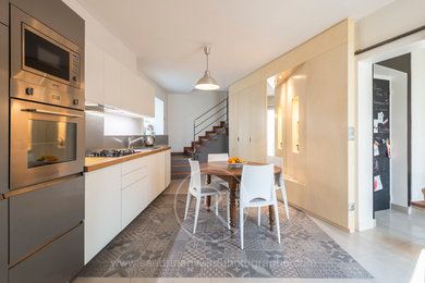 Photo of a mid-sized contemporary kitchen in Grenoble with light wood cabinets, wood benchtops, grey splashback and cement tiles.