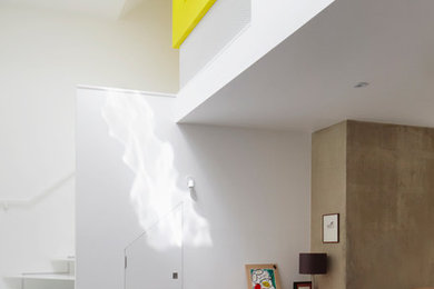This is an example of a small contemporary open plan living room in Cambridgeshire with white floors and white walls.