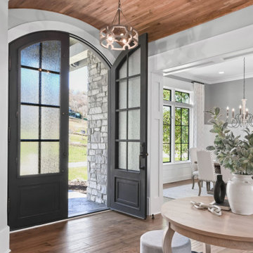 Luxury Modern Farmhouse Entry with Arched Black Steel Doors & Wood Ceiling