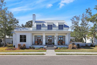 Huge cottage beige two-story brick house exterior idea in Jacksonville with a metal roof