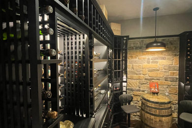 Example of a mid-sized medium tone wood floor and brown floor wine cellar design in Cincinnati with display racks