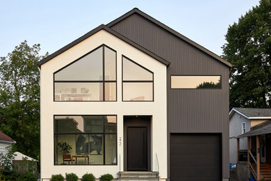 Scandinavian gray two-story stucco exterior home idea in Ottawa with a shingle roof and a black roof