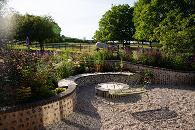 Medium sized contemporary back xeriscape partial sun garden for summer in Oxfordshire with natural stone paving.