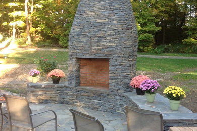 Arts and crafts backyard patio photo in New York with a fire pit