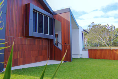 Design ideas for a contemporary split-level house exterior in Gold Coast - Tweed with wood siding and a metal roof.