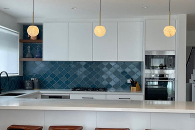 Photo of a contemporary kitchen in Sydney with blue splashback and ceramic splashback.