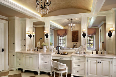 Example of a large classic limestone floor alcove shower design in New York with an undermount sink, white cabinets, beige walls and raised-panel cabinets
