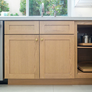 Modern White and Natural Oak Kitchen with Brass Hardware and Quartz Backsplash