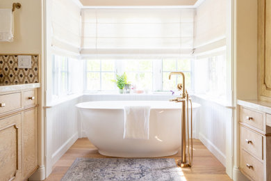 Example of a large french country master white tile and porcelain tile light wood floor, beige floor and double-sink bathroom design in Santa Barbara with light wood cabinets, a two-piece toilet, white walls, an undermount sink, quartzite countertops, a hinged shower door, beige countertops and a built-in vanity