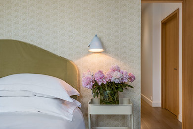 Photo of a mid-sized traditional master bedroom in Paris with beige walls, light hardwood floors and no fireplace.