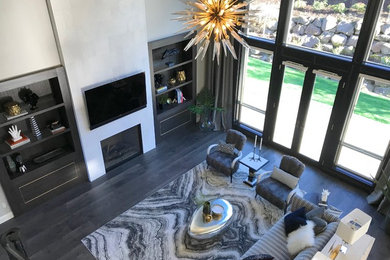 Photo of a large contemporary open concept living room in Portland with medium hardwood floors, a standard fireplace, a tile fireplace surround, a wall-mounted tv and black floor.