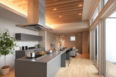 Design ideas for a modern grey and brown single-wall kitchen/diner in Tokyo with a submerged sink, beaded cabinets, grey cabinets, laminate countertops, medium hardwood flooring, an island, beige floors and grey worktops.
