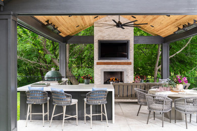 Example of a large transitional backyard stamped concrete patio kitchen design in Dallas with a roof extension