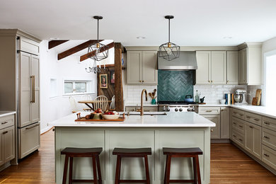 Inspiration for a country u-shaped kitchen in Chicago with an undermount sink, shaker cabinets, beige cabinets, green splashback, subway tile splashback, stainless steel appliances, medium hardwood floors, with island, brown floor and white benchtop.