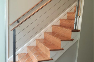 Ejemplo de escalera en L contemporánea pequeña con escalones de madera, contrahuellas de madera y barandilla de cable