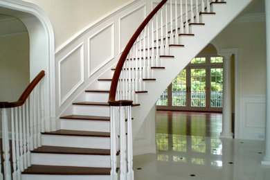 Example of a large classic wooden spiral staircase design in New York
