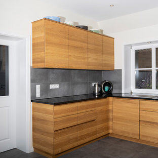 Huge contemporary kitchen pantry remodeling - Example of a huge trendy u-shaped gray floor kitchen pantry design in Bremen with a drop-in sink, flat-panel cabinets, light wood cabinets, granite countertops, no island and black countertops