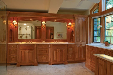 Corner shower - large traditional master marble floor and white floor corner shower idea in San Diego with raised-panel cabinets, medium tone wood cabinets, an undermount sink, marble countertops and a hinged shower door