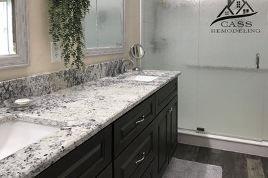 Photo of a mid-sized master bathroom in Tampa with white tile, vinyl floors, an undermount sink, granite benchtops, multi-coloured floor and multi-coloured benchtops.