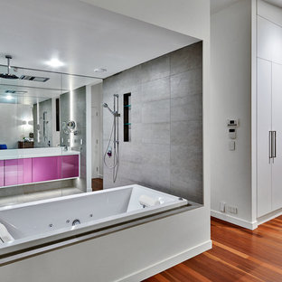 Idee per un'ampia stanza da bagno padronale moderna con ante lisce, ante viola, vasca da incasso, doccia a filo pavimento, piastrelle grigie, piastrelle in pietra, pareti bianche, pavimento con piastrelle in ceramica, lavabo integrato, top in quarzo composito, pavimento grigio e doccia aperta