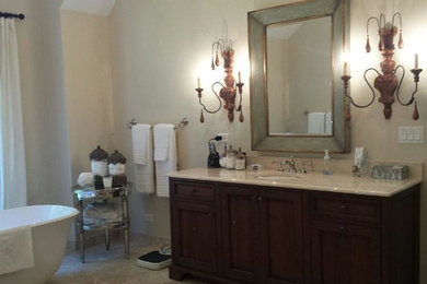 Transitional master travertine floor freestanding bathtub photo in Chicago with recessed-panel cabinets, dark wood cabinets, an undermount sink, beige walls and marble countertops