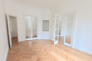 Idée de décoration pour une salle de séjour tradition de taille moyenne et fermée avec une salle de musique, un mur blanc, parquet clair et un sol marron.