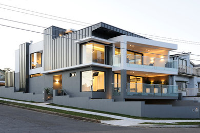 Photo of a large contemporary two-storey grey exterior in Sydney with mixed siding and a flat roof.